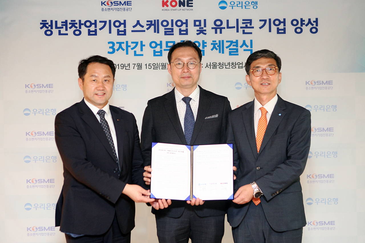 신명혁(오른쪽) 우리은행 중소기업그룹 부행장이 김은광(왼쪽) 중소벤처기업진흥공단 청년창업사관학교 교장, 장욱진(가운데) KONE 회장과 기념촬영을 하고 있다.