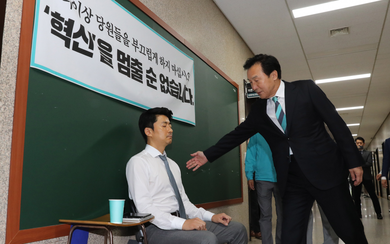 손학규 바른미래당 대표가 지난 15일 오전 최고위원회의에 참석하기 위해 국회 당회의실로 들어가며 회의실앞에서 당 혁신 요구 단식농성을 하고 있는 권성주 혁신위원의 어깨를 두드려주고 있다. [연합]