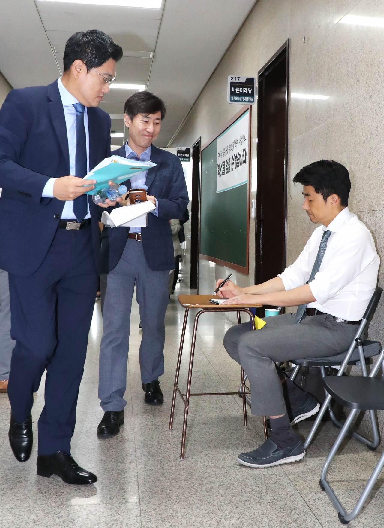 오신환 바른미래당 원내대표(왼쪽)와 하태경 의원이 16일 오전 국회에서 열린 원내대책회의에 참석하며 당 혁신을 요구하며 단식 농성중인 권성주 위원(오른쪽)을 바라보고 있다. [연합]