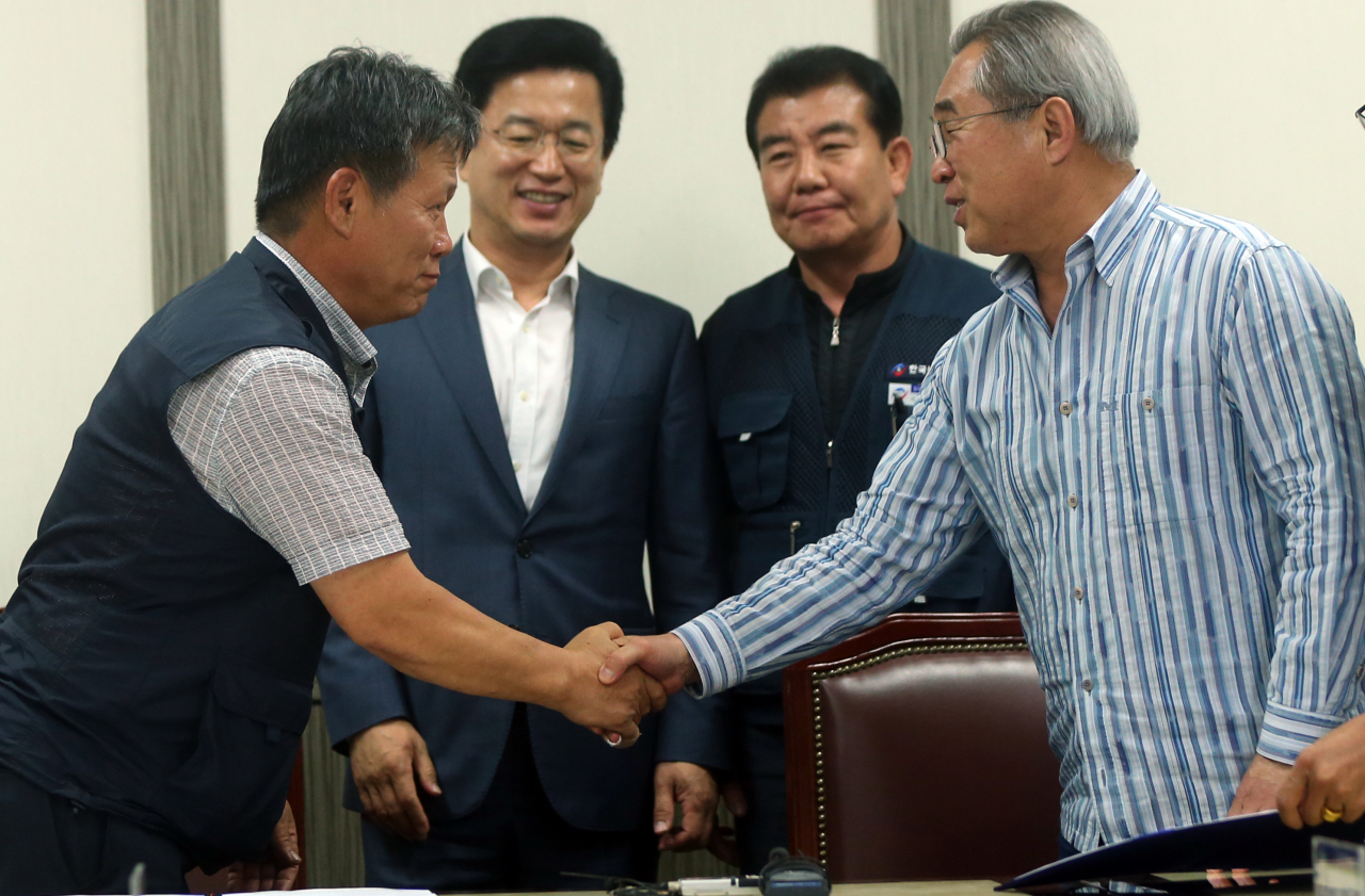 16일 대전 시내버스 노사가 마라톤협상 끝에 임금 인상률 등에 전격 합의하고 김희정 대전시지역버스노조 위원장(왼쪽)과 김광철 대전시내버스운송사업조합 이사장(오른쪽)이 악수하고 있다. 가운데는 허태정 대전시장. [연합]