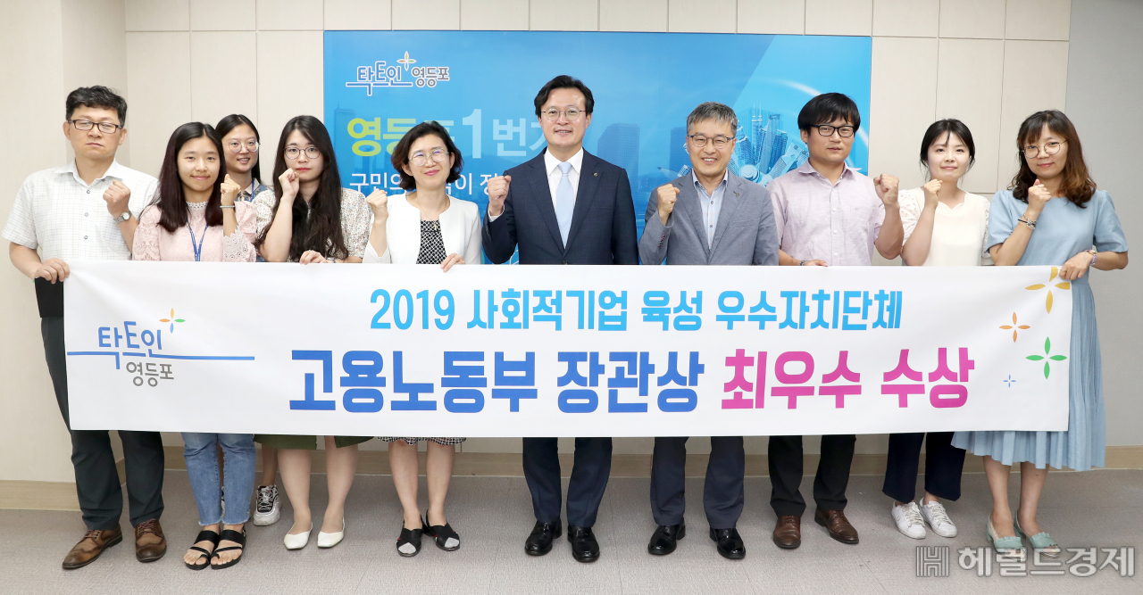 영등포구 채현일 구청장(가운데)과 사회적경제과 직원들이 17일 사회적 기업 육성 우수 자치단체 평가에서 최우수상를 수상하고 기념촬영을 하고 있다. [영등포구 제공]