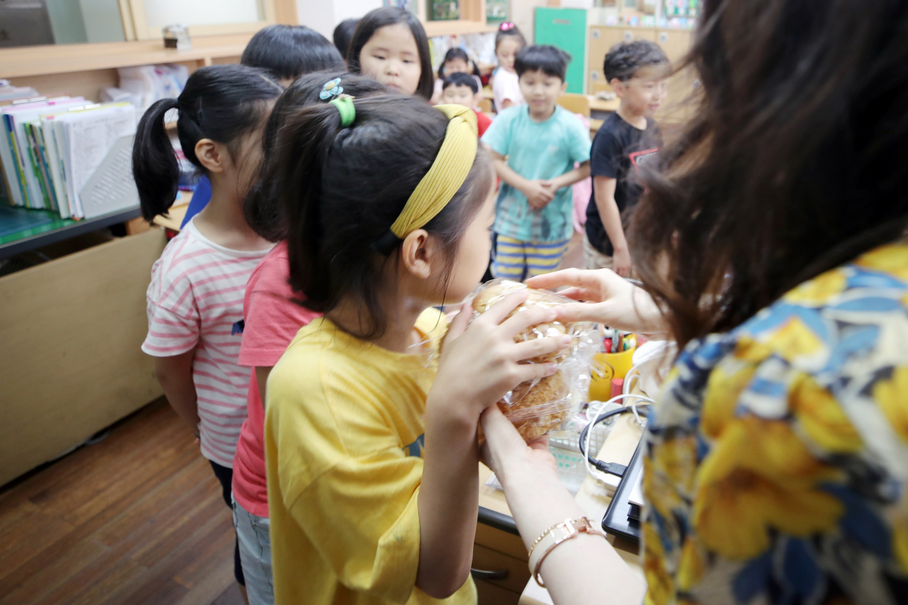 전국 학교 비정규직 연대회의 총파업으로 단체 급식이 중단된 3일 오전 광주 서구 한 초등학교에서 대체 급식으로 나온 빵을 받고 있다. 연합뉴스