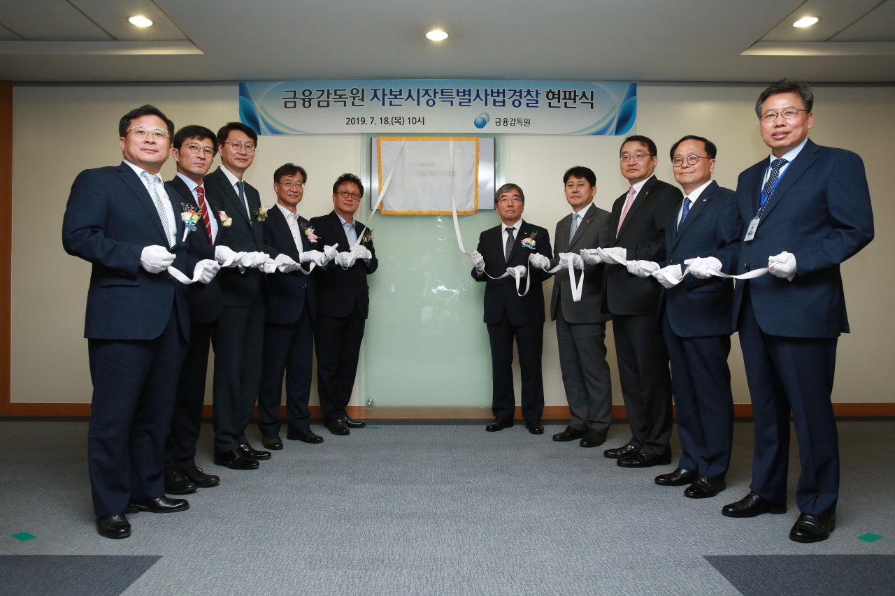 윤석헌 금융감독원장(오른쪽에서 다섯번째)이 18일 서울 여의도 본원에서 송준상 한국거래소 시장감시위원장(왼쪽) 등과 함께 금융감독원 자본시장 특별사법경찰(특사경) 현판식에 참석하고 있다.