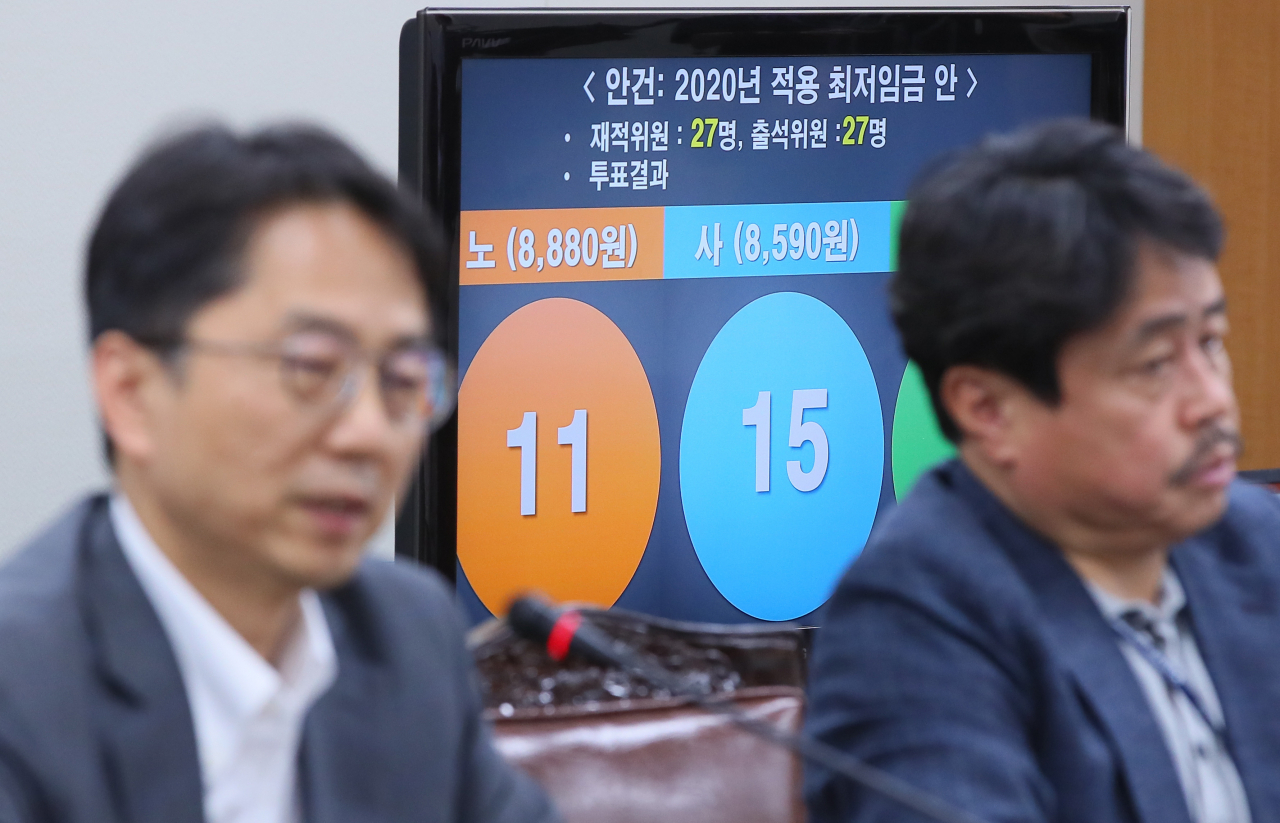 2020년 적용 최저임금이 올해보다 2.9% 오른 시간당 8590원으로 결정된 가운데, 최저임금이 경기부진과 일자리 위축 등의 원인이었다는 논란도 종지부를 찍을 것으로 보인다. 박준식 최저임금위원장과 권순원 숙명여대 경영학부 교수가 지난 12일 세종시 정부세종청사 최저임금위원회 전원회의실에서 투표결과를 배경으로 브리핑하고 있다. [연합]