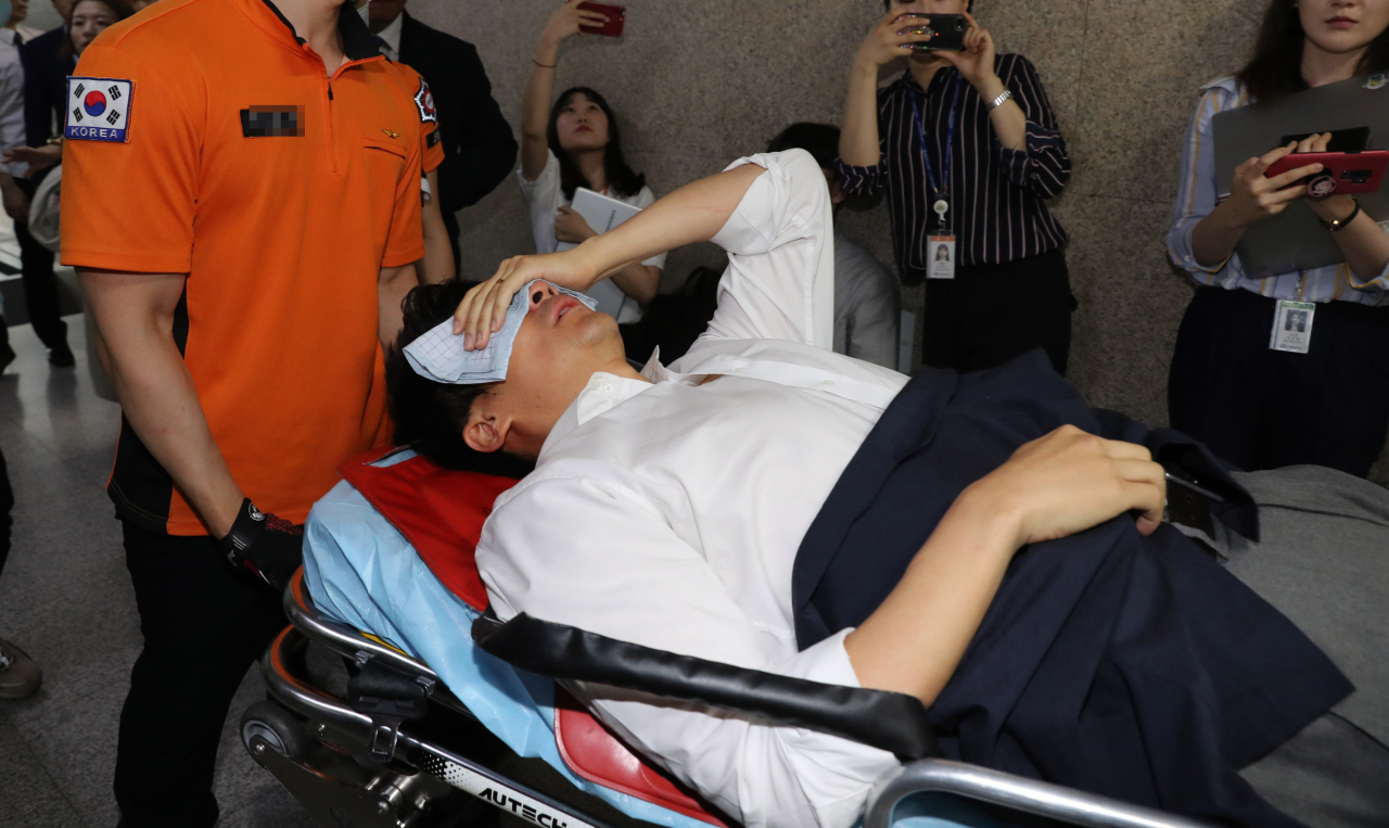 당 혁신 요구 단식 농성을 계속하던 권성주 바른미래당 혁신위원이 22일 오전 국회에서 최고위원회의를 마치고 이동하는 손학규 대표를 막아서다 넘어진 후 구급대원에 의해 이송되고 있다. [연합]