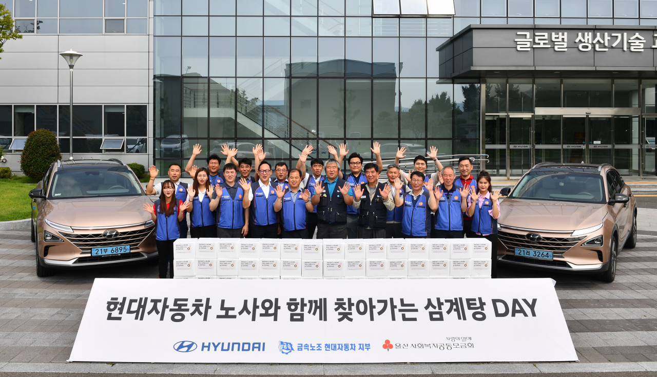 울산공장 사업부 봉사단과 관계자들이 배달하기 전 친환경차 넥쏘와 함께 '어르신들 건강하세요'를 외치며 기념촬영을 하고 있다.
