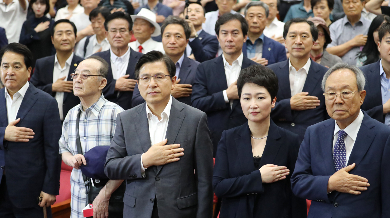 황교안 자유한국당 대표(왼쪽 세번째)가 22일 오후 국회 의원회관에서 열린 무소속 이언주 의원(오른쪽 두번째)의 '나는 왜 싸우는가' 출간 기념회에 참석해 국기에 경례하고 있다. [연합]