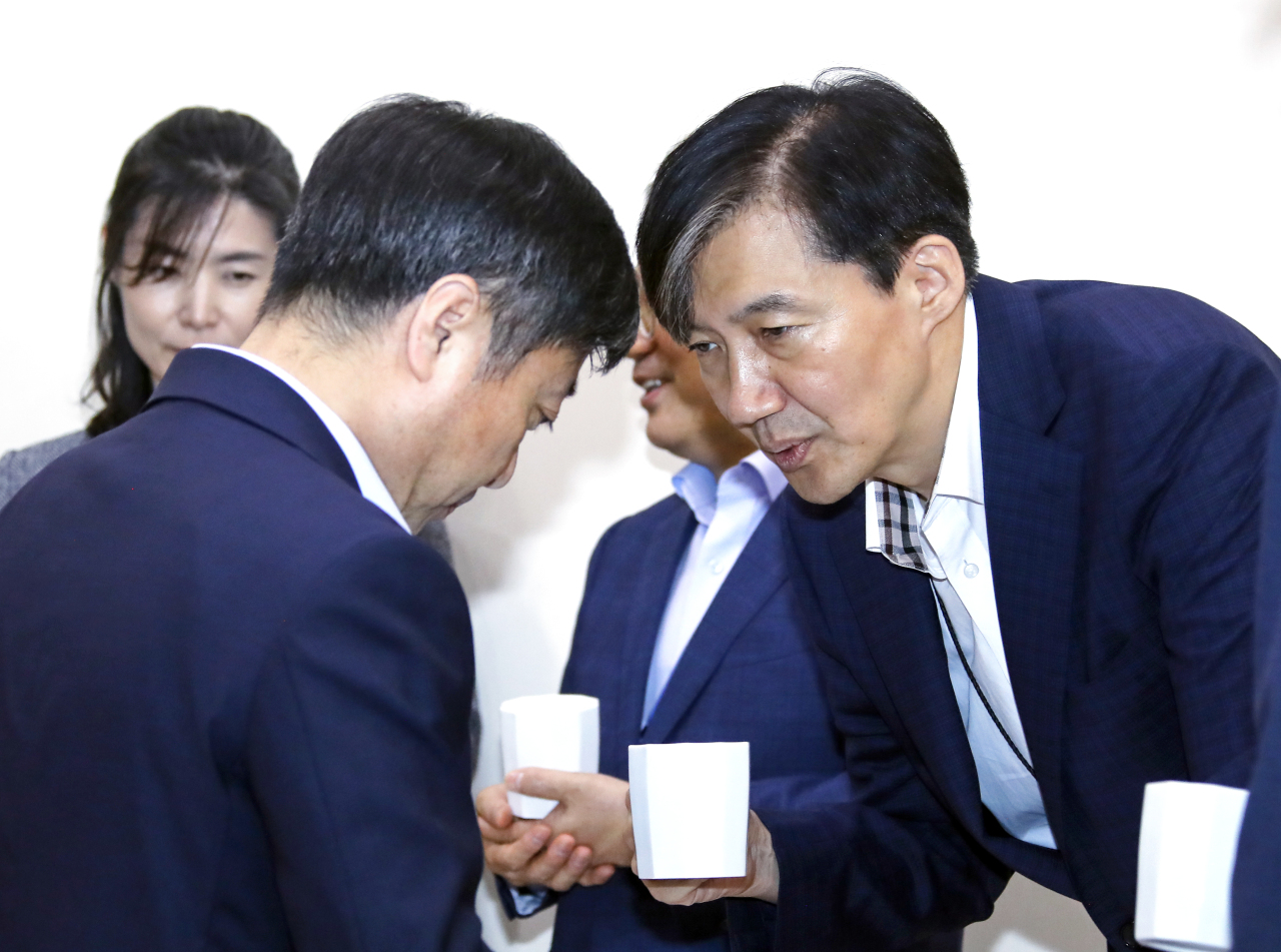 Cho Kuk, senior secretary to the president for civil affairs and justice (right), speaks with Senior Secretary to the President for Public Communication Yoon Do-han at Monday's senior aides meeting. Yonhap