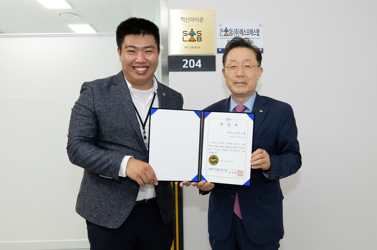 윤대희 신용보증기금 이사장(오른쪽)이 유니콘기업 육성을 위해 도입한 ‘제1기 혁신아이콘’ 선정기업 ㈜에스오에스랩을 23일 방문해 정지성 대표에게 선정서를 수여하고 기념촬영을 하고 있다.
