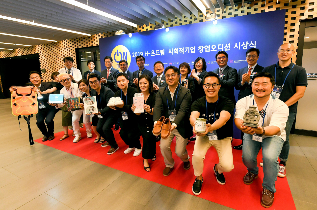 나영돈 고용노동부 고용정책실장(뒷줄 왼쪽에서 네번째), 권오규 정몽구 재단 이사장(뒷줄 왼쪽에서 다섯번째), 김인선 한국사회적기업진흥원 원장(뒷줄 왼쪽에서 일곱번째), 이병훈 상무 현대차 사회문화팀장(뒷줄 왼쪽에서 세번째), 이형근 현대차 정몽구 재단 이사(뒷줄 왼쪽에서 여섯번째)이 ‘H-온드림 사회적기업 창업오디션’ 8기 참가자들과 기념 촬영을 하고 있다. [현대차 제공]