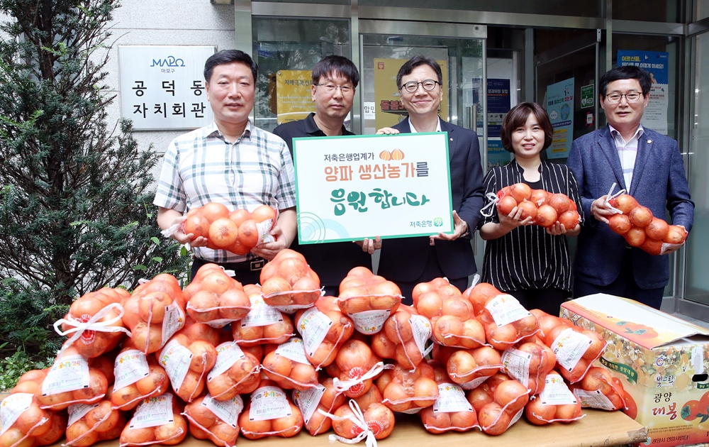 저축은행중앙회는 24일 양파 8t을 구매한 뒤 서울 공덕동 주민센터에 기부했다. 하은수 중앙회 전무(가운데)가 관계자들과 기념촬영을 하고 있다. [저축은행중앙회 제공]