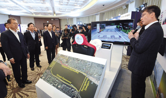 문재인 대통령이 24일 부산 해운대 ‘누리마루 APEC 하우스’에 마련된 LG유플러스 5G 자율주행차 시연존에서 강종오 LG유플러스 미래기술담당(가장 오른쪽)의 설명을 듣고 있다.  [LG유플러스 제공]