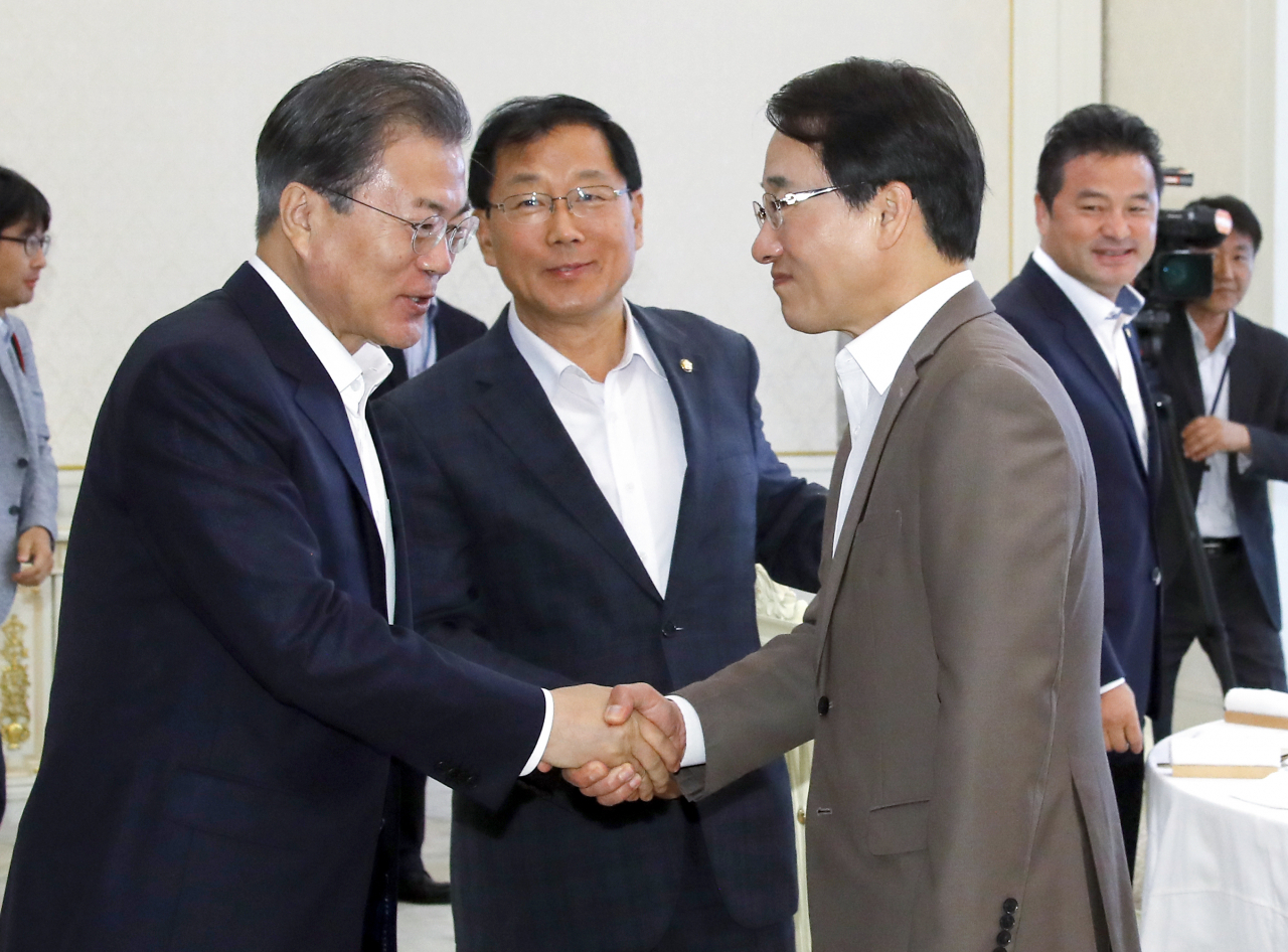 문재인 대통령이 23일 오후 청와대에서 열린 더불어민주당 원내대표단 초청 오찬 간담회에 입장하며 이원욱 수석부대표(오른쪽)와 인사하고 있다. 가운데는 윤후덕 부대표. [연합]