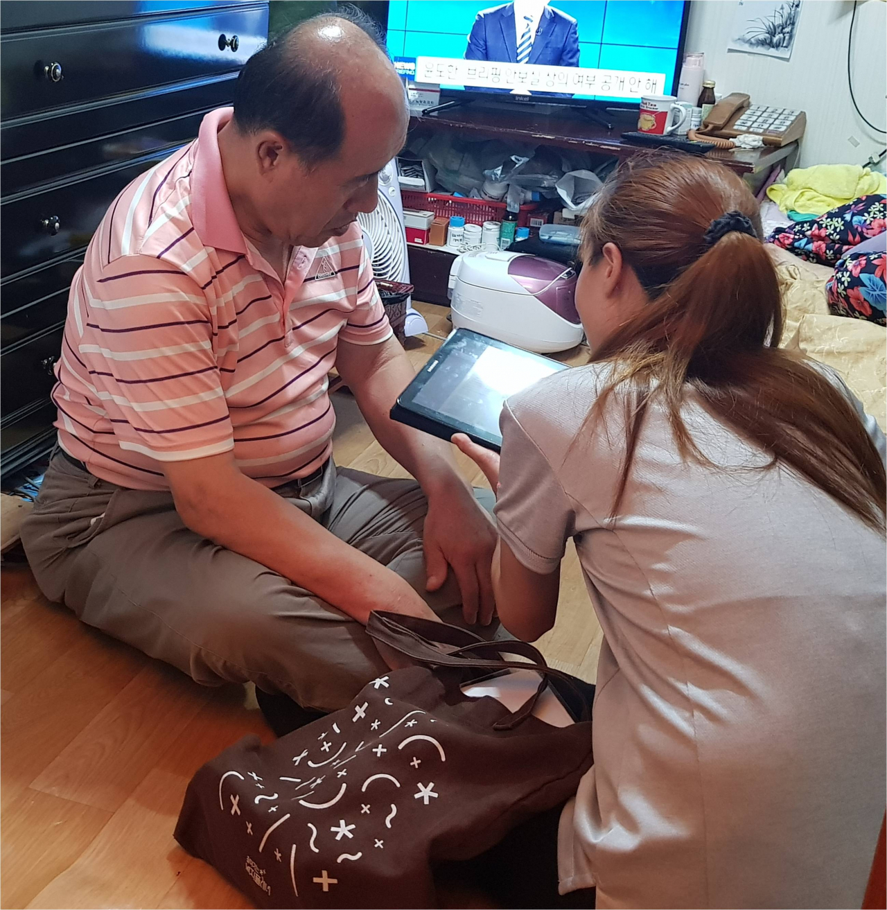 올해 7월 흑석동 복지플래너가 어르신 가정을 방문해 태블릿PC를 이용해 상담을 진행하고 있다. [동작구 제공]