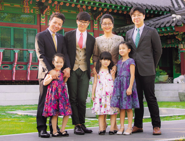 오창화 대표가 다섯 자녀와 함께 활짝 웃고 있다. 오 대표 부부 앞에 서있는 쌍둥이(앞줄 왼쪽부터 첫번째 두번째)가 가슴으로 낳은 두 딸이다. [진원무역 제공]