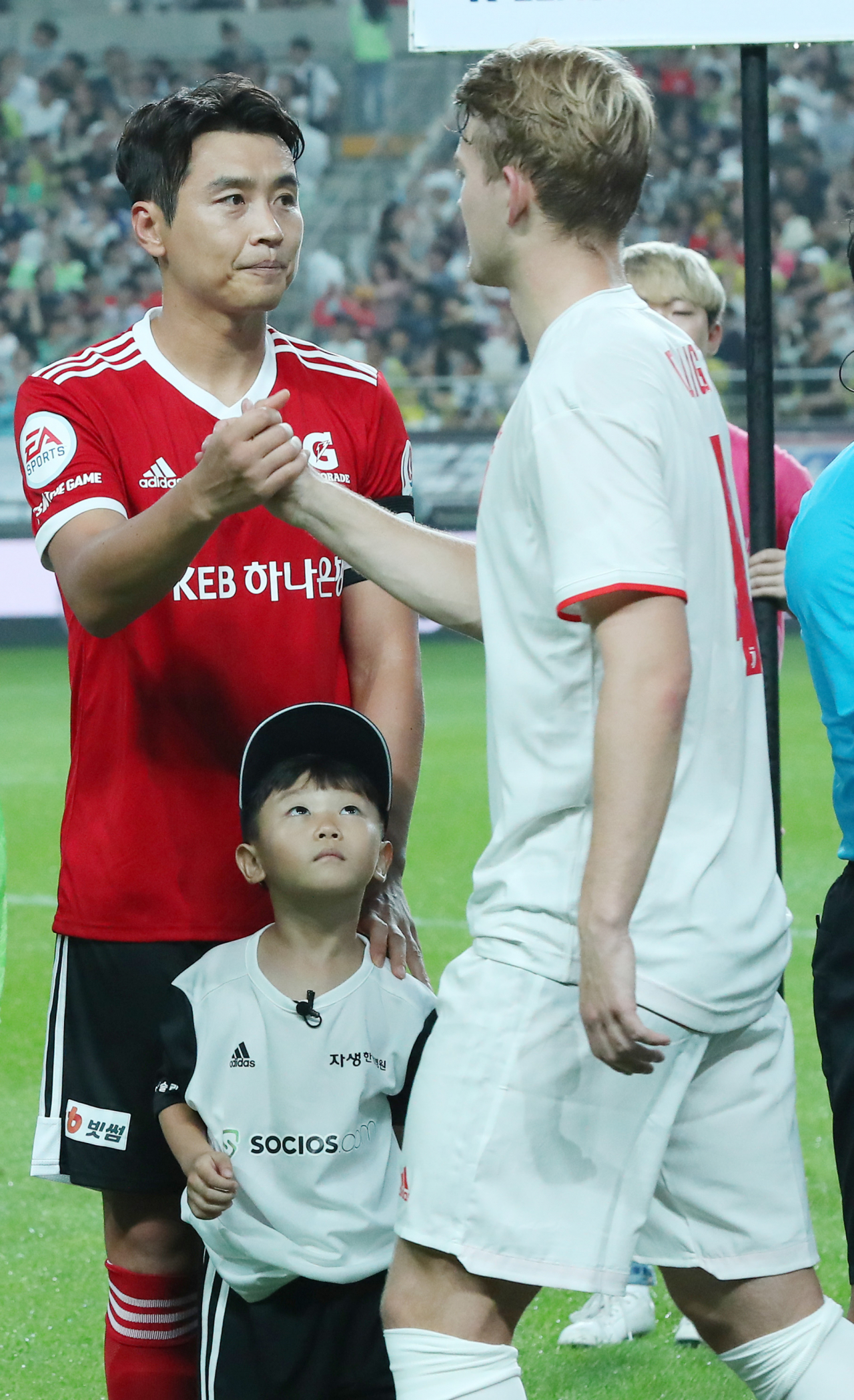 26일 오후 서울 마포구 성산동 서울월드컵경기장에서 열린 하나원큐 팀 K리그와 유벤투스 FC의 친선경기. 이동국 선수의 아들 시안군이 아빠와 인사하는 유벤투스의 더리흐트를 바라보고 있다. [연합]
