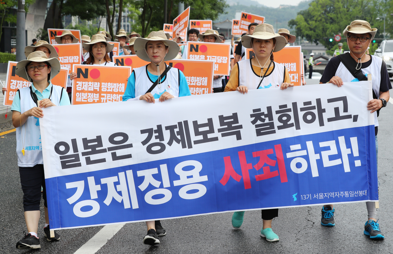서울지역 자주통일선봉대 관계자들이 28일 서울 종로구 주한일본대사관 앞에서 '민족자주대행진 선포 100인 기자회견'을 마친 뒤 일본의 강제동원 사죄배상 촉구 및 경제보복 규탄 거리행진을 펼치고 있다. [연합]