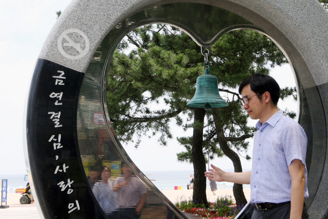 2020년 12월부터 현재 담뱃갑의 50%인 흡연 경고 그림·문구의 표기 면적이 75%(경고 그림 55%+문구 20%)까지 확대될 전망이다. 보건복지부는 이 같은 내용을 담은 관련 법령을 30일 입법 예고했다. 복지부와 한국건강증진개발원이 지난 23일 강원 강릉 경포해수욕장에서 개최한 ‘금연 결심의 종’ 제막식에서 한 참석자가 종을 치고 있다. [연합]