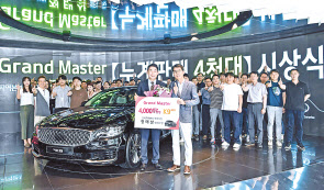누계판매 4000대를 달성한 ‘그랜드 마스터’ 정태삼 영업부장(왼쪽)이 권혁호 기아차 국내영업본부장과 기념촬영을 하고 있다.