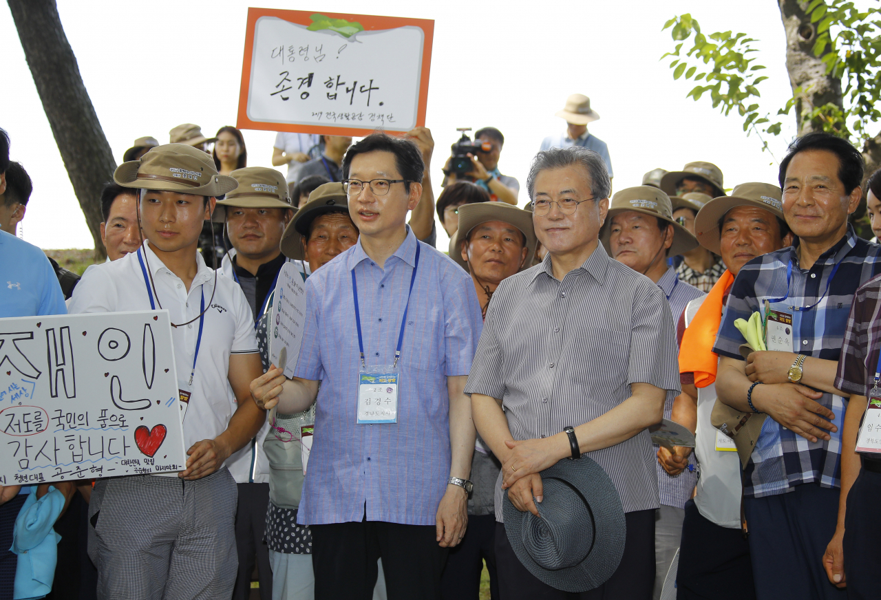 문재인 대통령이 30일 오후 경남 거제시 저도에서 변광용 거제시장의 보고를 듣고 있다. 왼쪽은 김경수 경남도지사. 이날 문 대통령은 저도 전 거주민 및 일반 시민 등과 섬을 산책했다. [연합뉴스]
