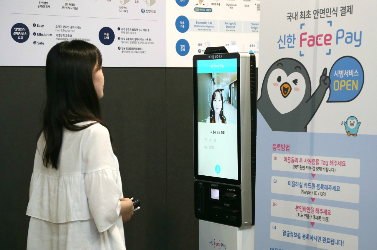 신한카드는 임직원을 대상으로 얼굴만으로 결제하는 ‘신한 페이스페이’ 서비스 운영을 시작했다고 1일 밝혔다. 신한카드 직원이 사내에 설치된 안면인식 등록 키오스크에서 본인확인 및 카드정보와 안면정보를 등록하고 있다. (제공 신한카드)