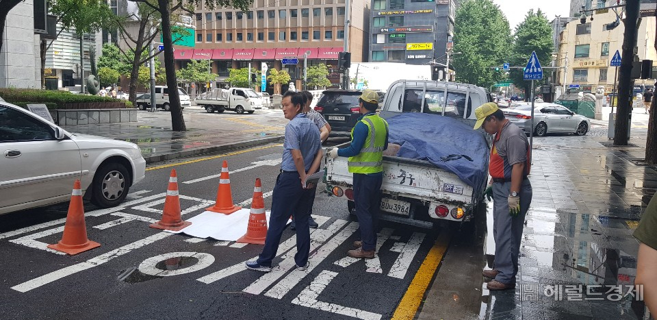 1일 내린 비로 청계천 1가 효령빌딩 앞에 약 1m 크기의 싱크홀이 생겨 서울 중구에서 나와 하얀 포장으로 덮어 차량이 다니지 못하도록 임시 조치를 취하고 있다. 정희조 기자/checho@heraldcorp.com