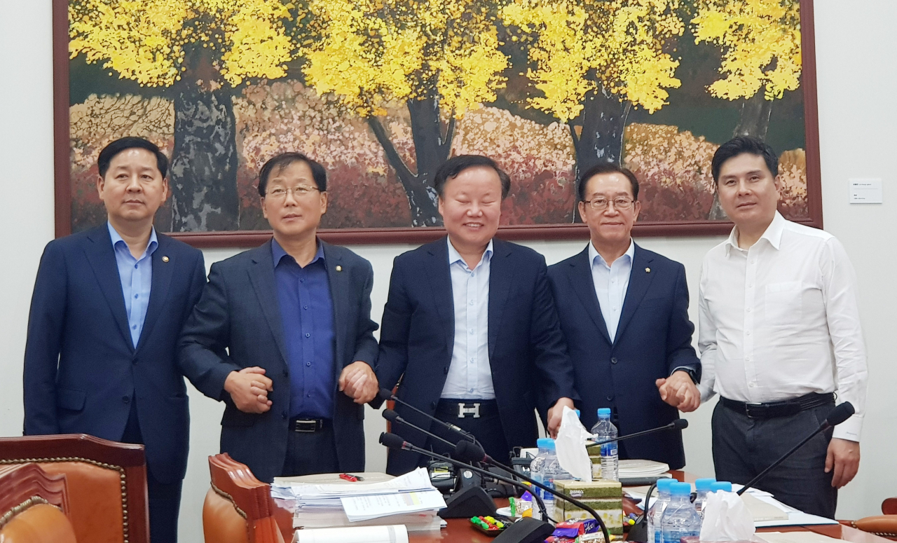 김재원 예결위원장(가운데)과 구윤철 기획재정부 2차관(왼쪽부터), 더불어민주당 소속 윤후덕 간사, 자유한국당 소속 이종배 간사, 바른미래당 소속 지상욱 간사가 2일 새벽 국회에서 예결위 간사회의를 갖기 전 손을 맞잡고 있다. [연합]