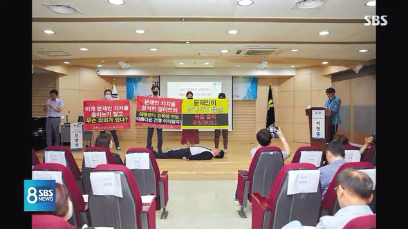 지난달 30일 건강보함심사평가원 서울사무소에서 열린 ‘제43회 심평포럼’에서 임현택 대한소아청소년과의사회장과 의사회원들이 단상에서 시위를 하고 있다. [SBS 방송화면 캡처, 연합]