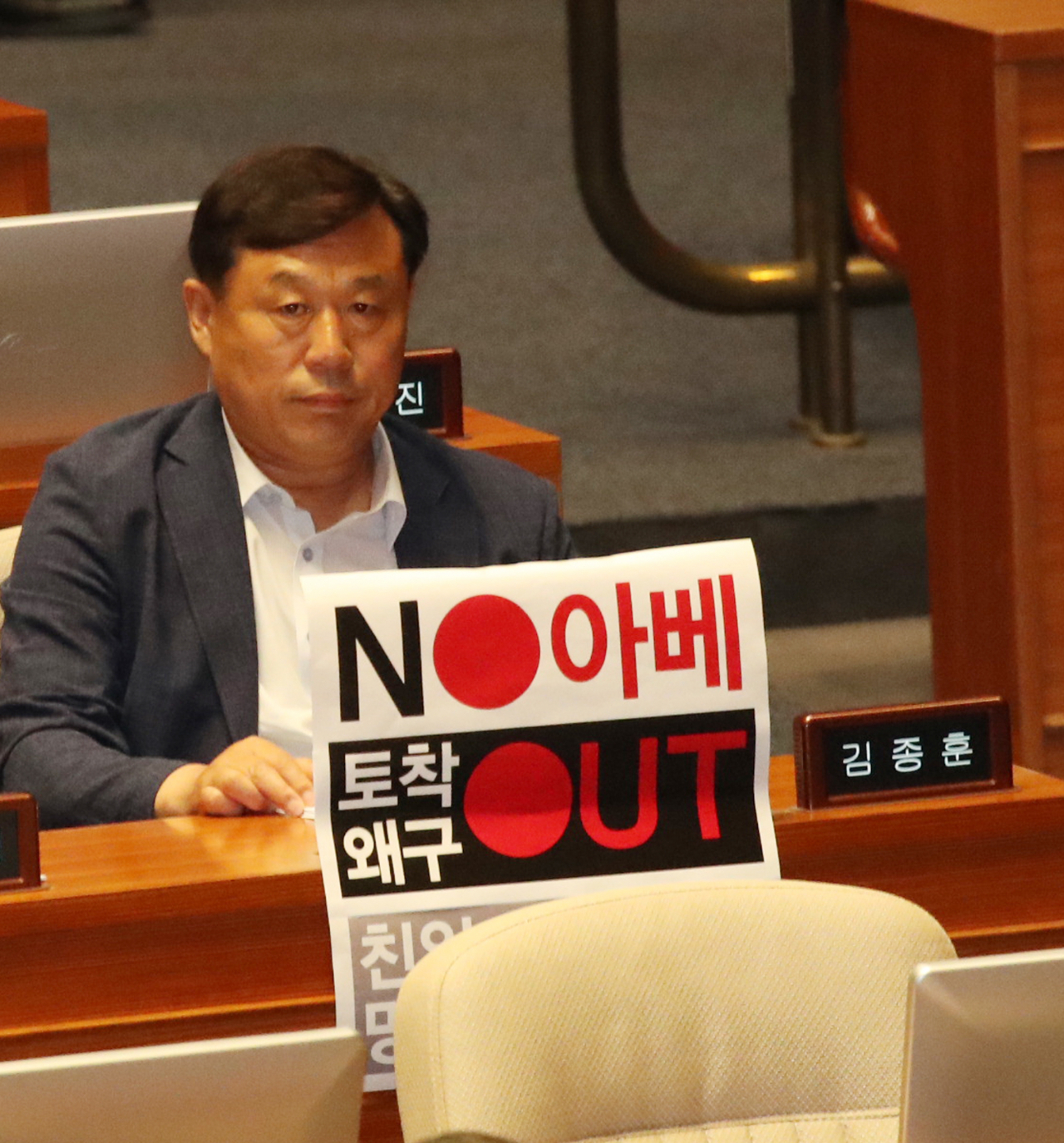 첨단 바이오법이 통과된 2일 국회 본회의에는 일본 아베와 국내 극소수 보수친일파를 규탄하는 팻말이 등장했다. 김종훈 의원이 손팻말을 좌석 앞에 설치했다. [연합]