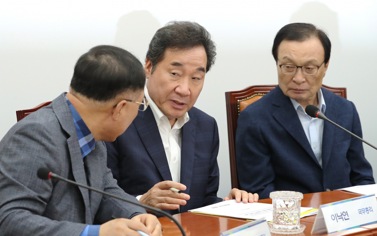 이낙연 국무총리(가운데)와 홍남기 경제부총리 겸 기획재정부 장관이 4일 오후 국회에서 일본의 화이트리스트(백색국가 명단) 배제 조치에 따른 대응방안을 논의하기 위해 열린 당정청협의회에서 대화하고 있다. 오른쪽은 이해찬 대표.[ 연합]