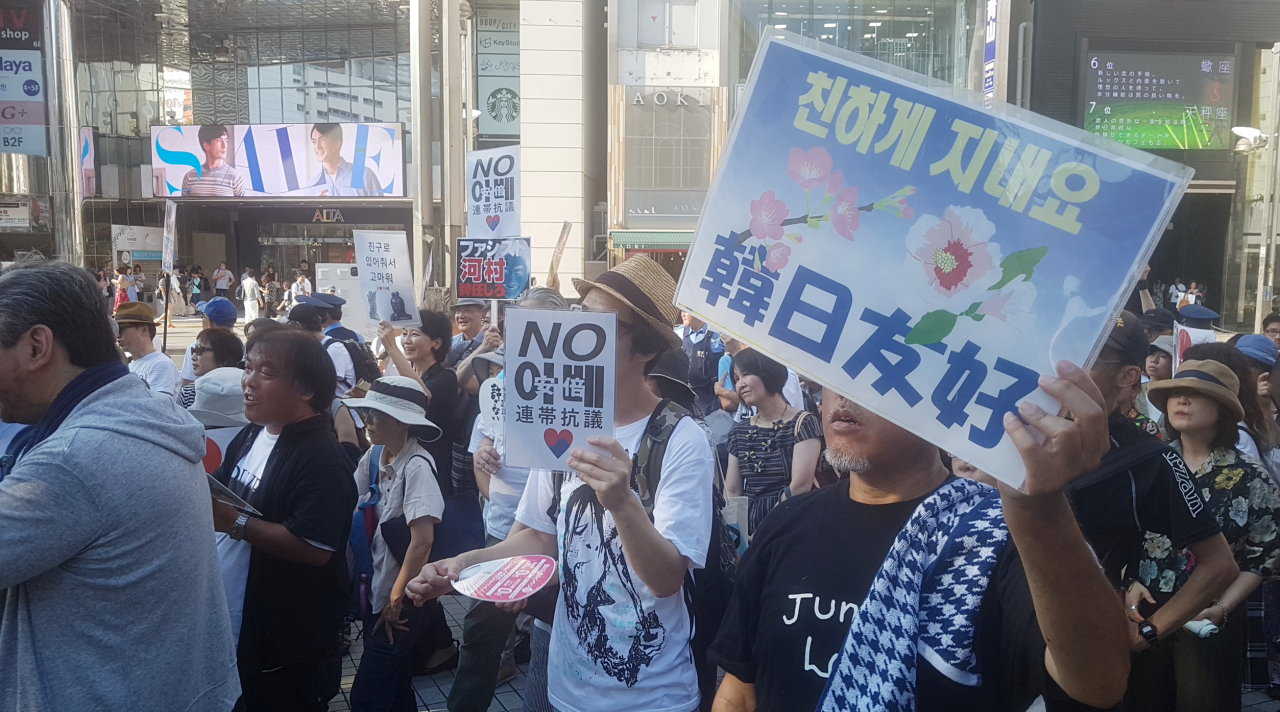 4일 일본 신주쿠에서 진행된 반 아베 시위에서 일본인 참가자들이 피켓을 들고 있는 모습. [연합뉴스]