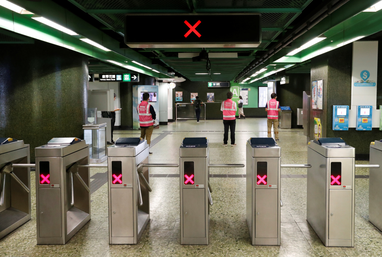 Fortress Hill station staff stand in front of gantries as the station is temporary closed due to disruption of the Mass Transit Railway (MTR) services by protesters, in Hong Kong (Reuters-Yonhap)