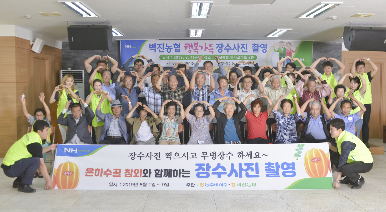 지난 1일 농우바이오와 성주 벽진농협이 함께한 장수사진 촬영 행사에 참석한 농업인들이 머리 위로 하트를 표현하며 감사를 표하고 있다. [농협 제공]