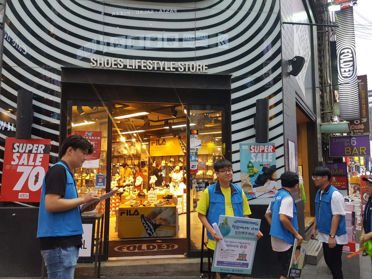 서울 YWCA 청소년단원들이 명동거리에서 문닫고 냉방하는 에너지절약 실천 '착한가게를 알리기 위한 캠페인'을 펼치고 있다. [한국에너지공단 제공]