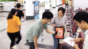 CJ ENM 오쇼핑부문 직원들이 업계 최초로 개발된 직원 교육용 전략 시뮬레이션 게임 ‘OLA(올라)’에 참여해 태블릿PC에 NFC(근거리무선통신) 태그 장치를 접촉하고 있다.