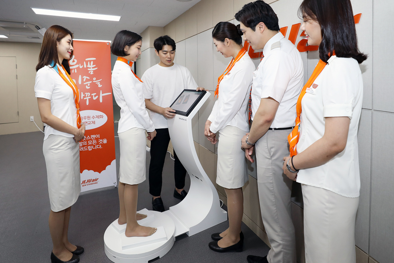 제주항공 승무원들이 사내에 설치된 3D 풋 스캔 장치에서 발을 측정하고 있다. [제주항공 제공]