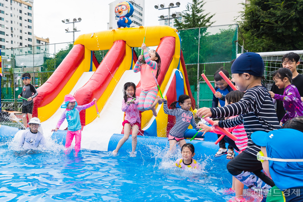 　지난 7일 서울 광진구 자양고등학교 운동장에 설치된 물놀이장에서 어린이들이 폭염속에서 신나게 물놀이를 하고 있다.　광진구 자양3동주민센터와 주민자치위원회는 가까운 곳에서 시원하게 물놀이를 즐길 수 있도록 7일 오전 11시부터 오후 4시까지 운영 자양고등학교 운동장에 물놀이장을 설치, 더위에 지친 주민들에게 제대로 된 피서지 역할을 했다. [광진구]