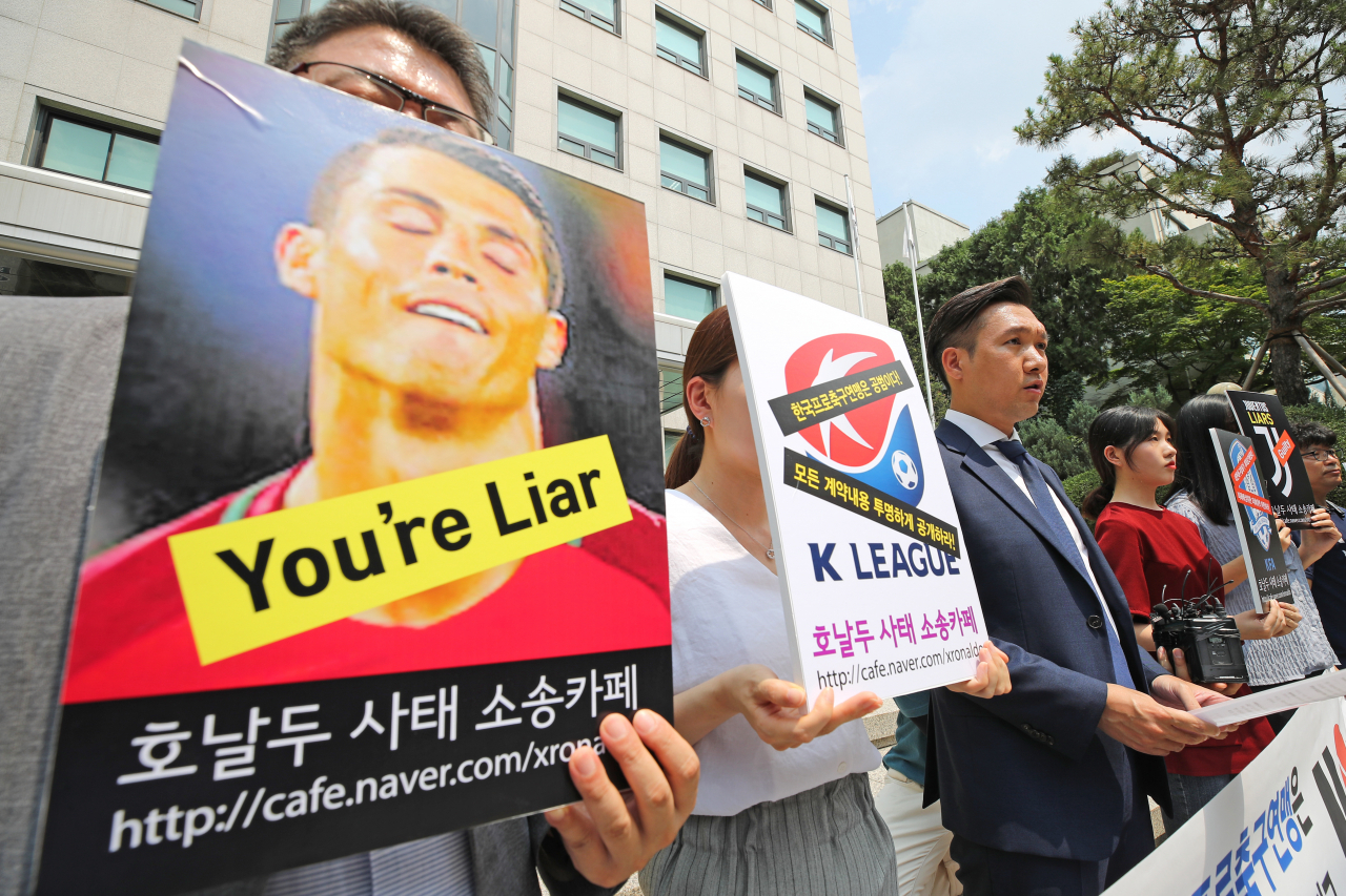네이버 '호날두 사태 소송카페' 관계자들이 지난 5일 오후 서울 종로구 대한축구협회 축구회관 앞에서 기자회견을 열고 대한축구협회와 한국프로축구연맹에 크리스티아누 호날두(유벤투스) 노쇼 논란 피해자들의 입장료 전액 배상을 촉구하는 손피켓을 들고 있다. [연합]
