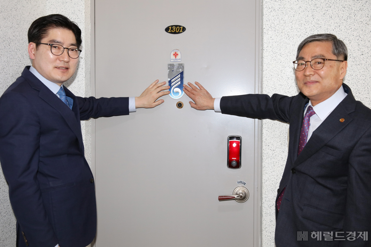 이정훈 구청장(왼쪽)이 지난 4월8일 독립운동가 고 이정수 애국지사 자녀 이춘근 씨 자택에 국가유공자 명패를 달고 있다. [강동구 제공]