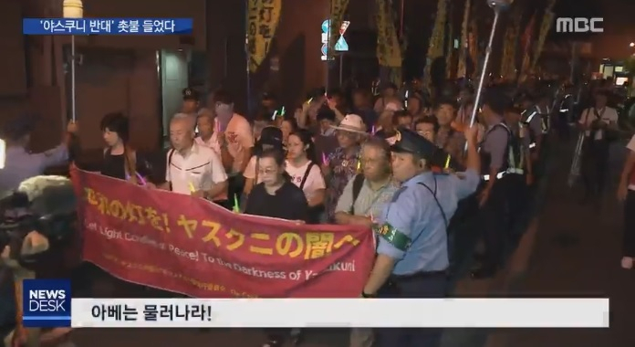 10일 ‘야스쿠니 반대 도쿄 촛불행동’을 지지하는 일본 시민 400여명이 이날 저녁 도쿄 도심에서 합사 취소와 아베 퇴진을 외치며 거리행진을 벌이고 있는 모습. [MBC 뉴스데스크 캡처]