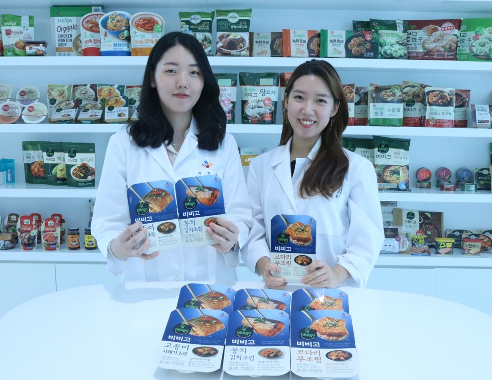 경기도 수원에 위치한 CJ제일제당의 식품연구소 CJ블로썸파크에서 만난 최정인(왼쪽), 안세은(오른쪽) 연구원이 1년간 개발을 담당한 비비고 생선조림 3종(고등어시래기조림·코다리무조림·꽁치김치조림)을 들고 있다. [CJ제일제당 제공]