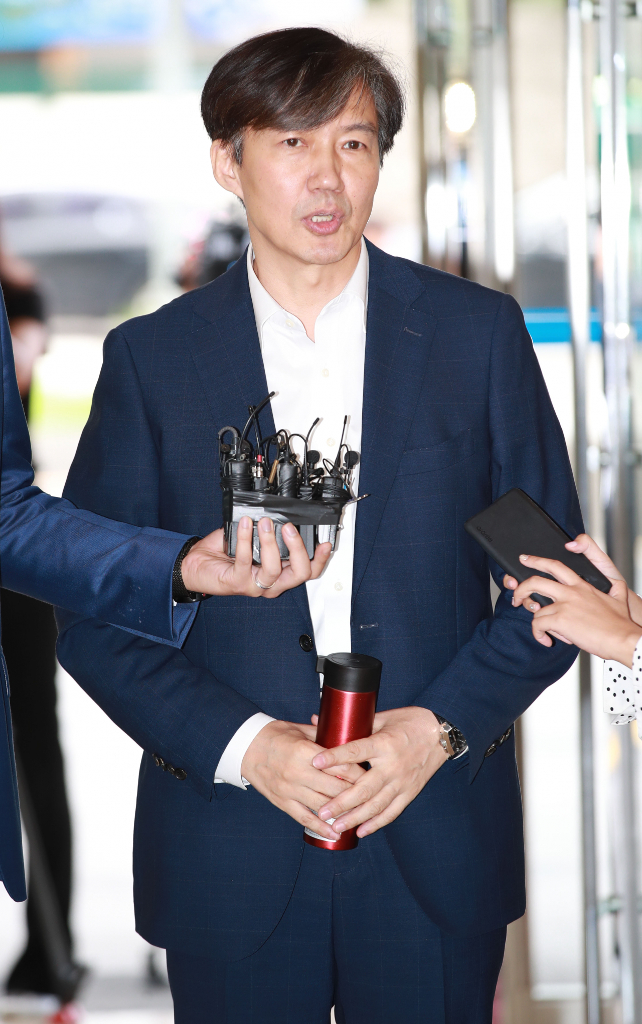 조국 법무부 장관 후보자가 13일 오전 인사청문회 준비 사무실이 마련된 서울 종로구 사직로 적선현대빌딩으로 출근하며 취재진의 질문에 답하고 있다. [연합]