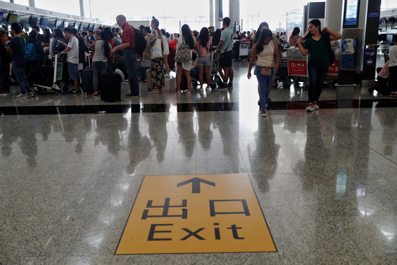 시위대의 기습적인 점거로 폐쇄됐던 홍콩국제공항 운영이 13일(현지시간) 오전 재개되면서, 공항 이용객들이 줄을 짓고 있는 모습. [로이터]
