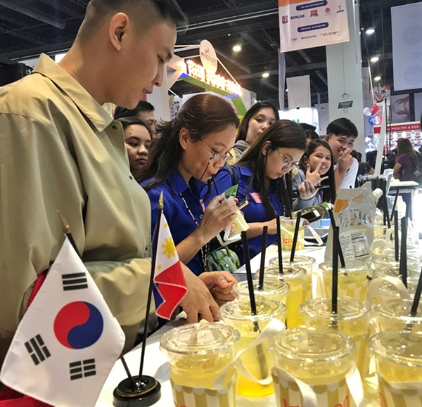 ‘필리핀식품박람회(WOFEX 2019)’ 한국관을 찾은 현지인 등 방문객들이 시원한 여름 음료로 각광받고 있는 유자에이드를 시식하고 있다. [aT 제공]