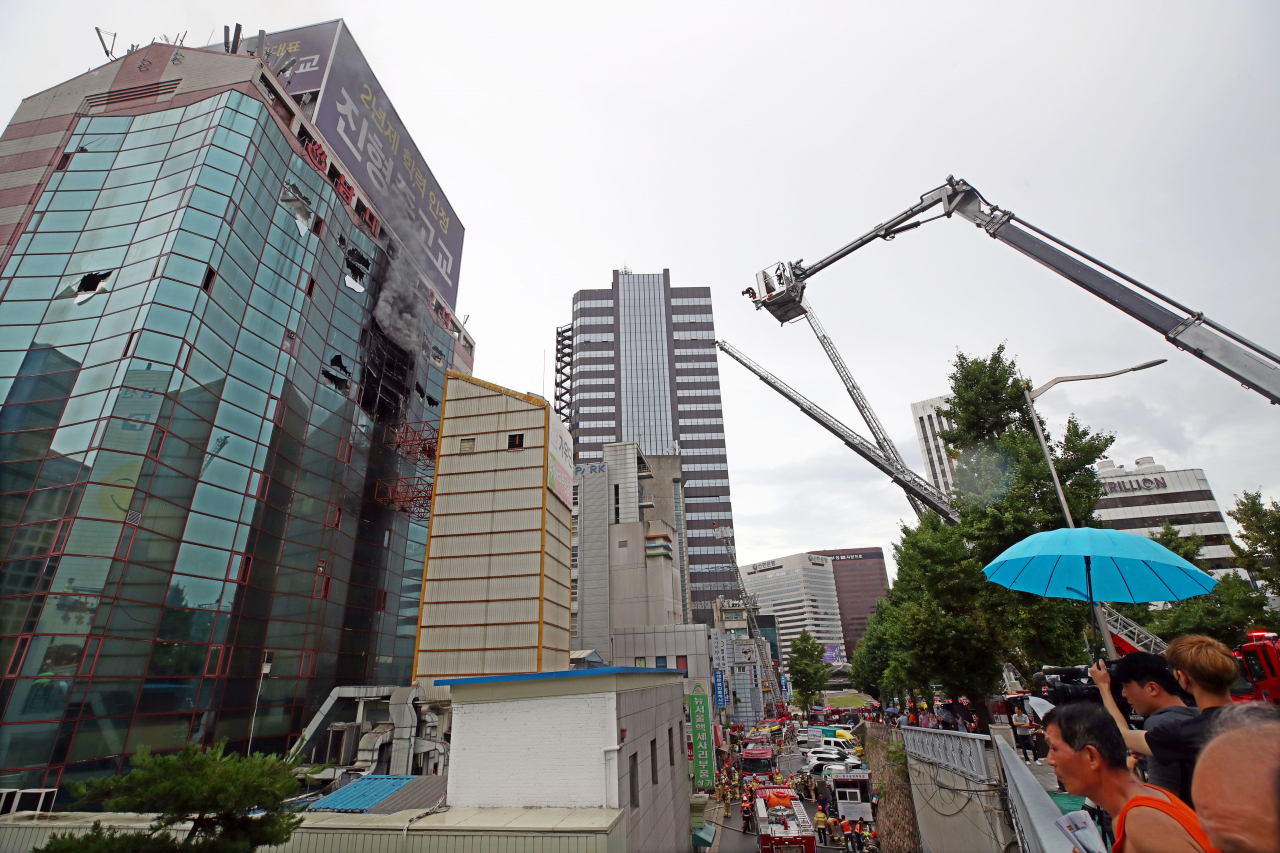 15일 오전 서울 중구 남대문오피스텔 8층에서 원인미상의 화재가 발생해 소방대원들이 화재진압 작업을 하고 있다. [연합뉴스]