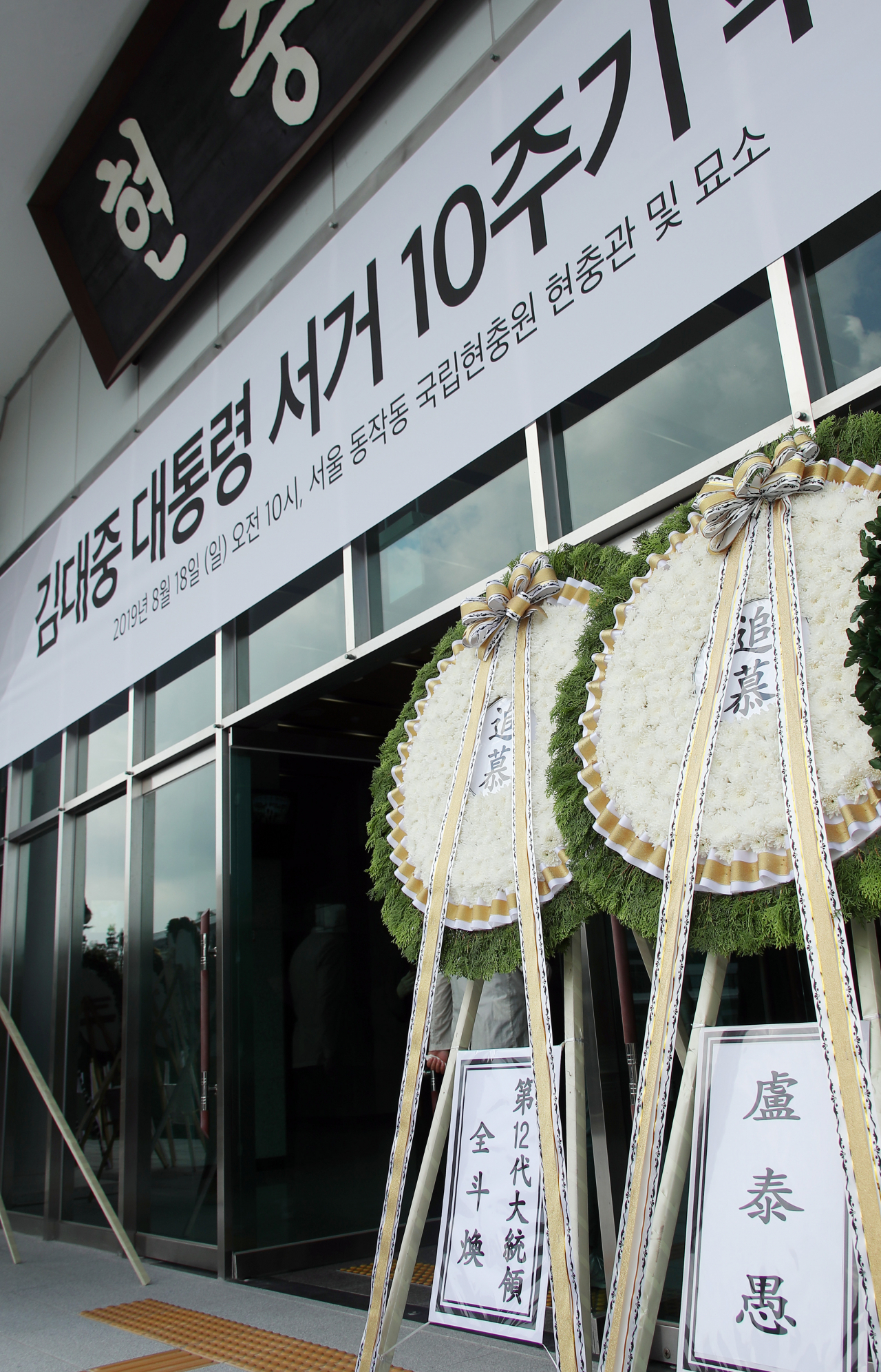 18일 오전 고(故) 김대중(DJ) 전 대통령 서거 10주기 추도식이 열리는 국립서울현충원 현충관 앞에 전두환 전 대통령과 노태우 전 대통령의 화환이 놓여있다. 연합뉴스