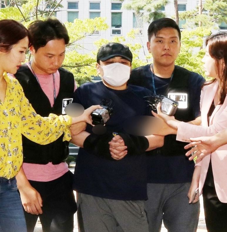 The suspect (center) told reporters Sunday the victim "started it first." (Yonhap)