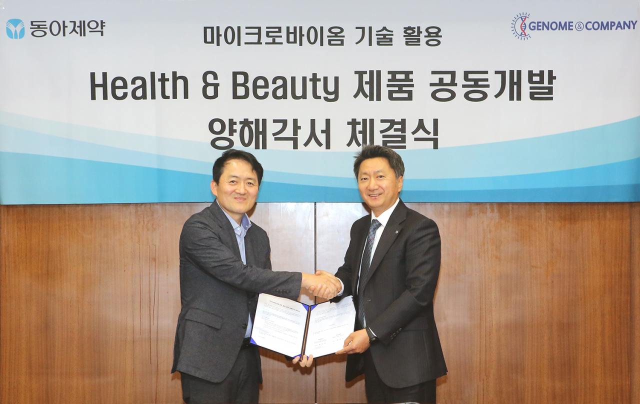 동아제약-지놈앤컴퍼니 간 Health & Beauty 제품 공동개발 업무협약 체결식에서 최호진 동아제약 사장(오른쪽)과 배지수 지놈앤컴퍼니 대표가 협약서를 맞잡은뒤 악수하고 있다.