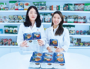 경기도 수원에 위치한 CJ제일제당의 식품연구소 CJ블로썸파크에서 지난 1일 만난 최정인(왼쪽), 안세은(오른쪽) 연구원이 1년간 개발을 담당한 비비고 생선조림 3종(고등어시래기조림·코다리무조림·꽁치김치조림)을 들고 있다. [CJ제일제당 제공]