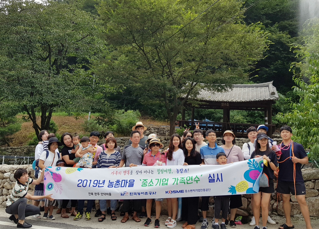 농어촌공사와 중소벤처기업진흥공단이 공동으로 마련한 농촌체험마을 중소기업가족연수 참가자들이 기념촬영을 하고 있다. [한국농어촌공사 제공]